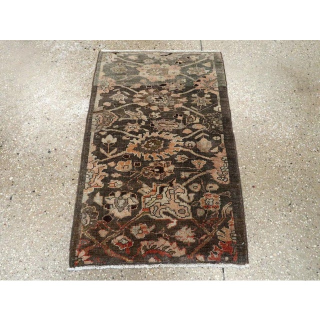 This early 20th-century Persian Malayer sampler rug presents a compact yet richly varied floral composition across a deep...
