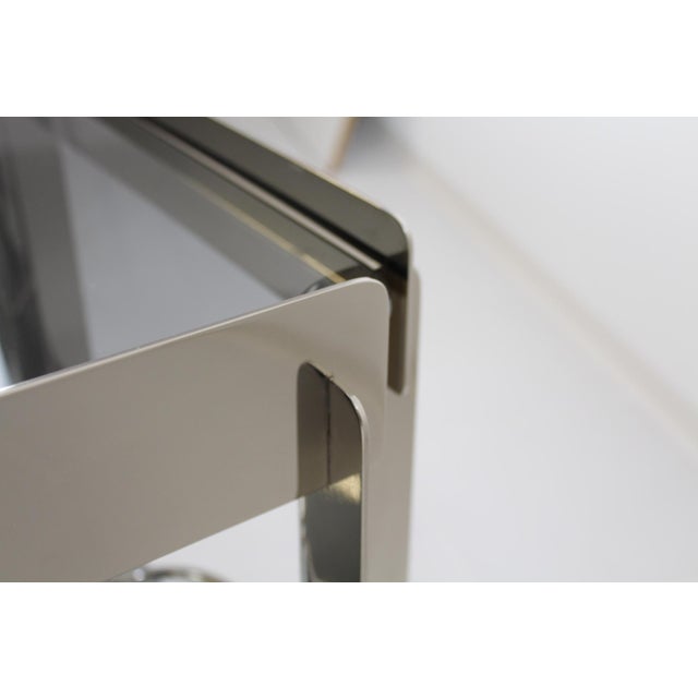 Extremely unusual design, high-quality workmanship, light gray glass shelves in a chrome-plated stainless steel frame.
