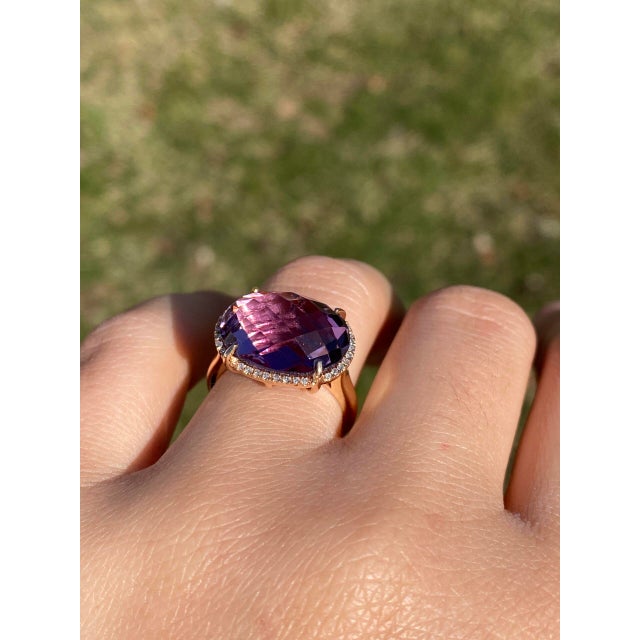 The Nelle: Checkerboard Cut Natural Amethyst and Diamond Halo Ring in Rose Gold.This impressive ring centers on an oval...