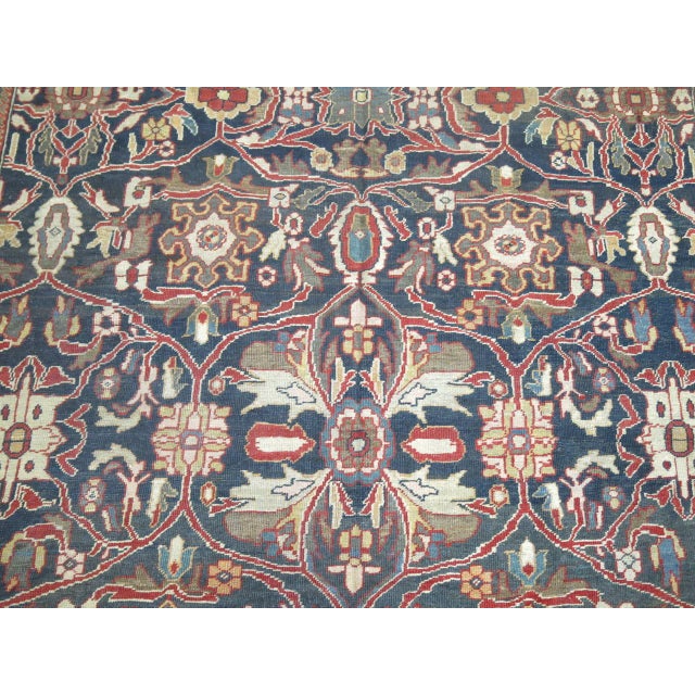A late 19th century Persian Sultanabad rug featuring a bold masculine all-over motif on a steel blue ground surrounded by...