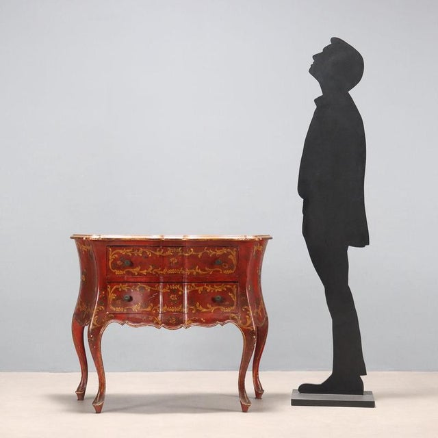 Small chest of drawers in Venetian Late Baroque style. Burgundy lacquer with gold-painted leafy and scroll decorations,...