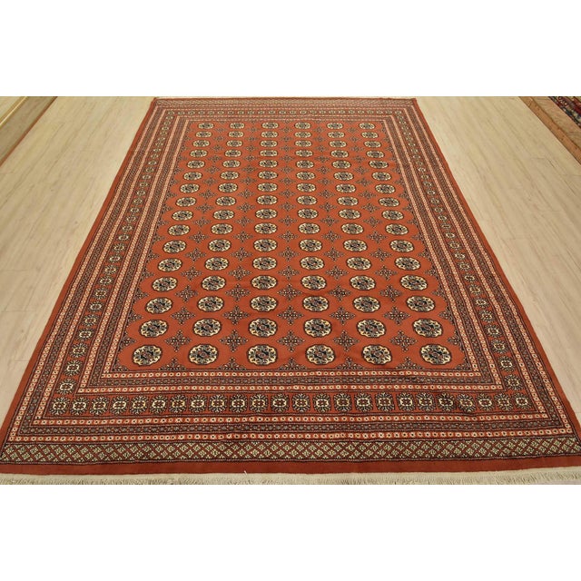 A tribal Bokhara rug, hand-knotted with fine wool on a cotton foundation. This rug features rows of repeating medallions...