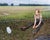 Salt by Cody Erickson | Oil Painting of a girl sitting in a field with a salt block nearby For Sale
