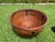 Handwoven pencil rattan basket featuring a substantial rounded form with leather-wrapped rim and hand-forged iron...