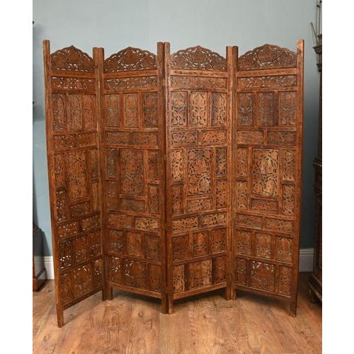 A highly decorative Indian carved hardwood folding screen in the Mughal revival manner. Constructed as a multi-panel...