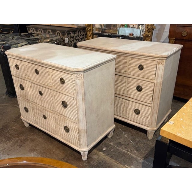 This product is a pair of Swedish Neo-Classical style bedside tables, that are hand painted in a white patina. These...