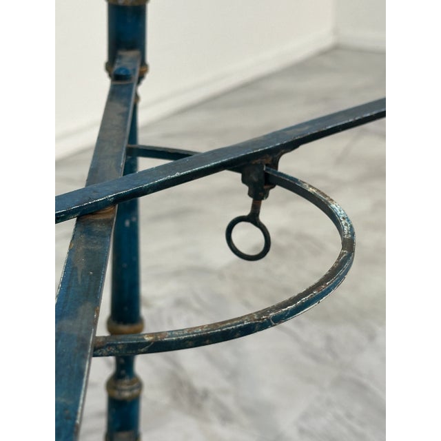 This metal trolley is a vintage piece featuring a frame designed to hold two decorative trays. The trays are elaborately...