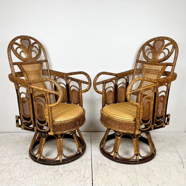 Mid century pair of rattan cane swivel chairs. Ornate woven wrapped frames with cane panels. Caning is woven in a...