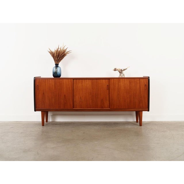 The sideboard was made in the 1970s, Danish production. The structure is covered with teak veneer. Legs made of solid...
