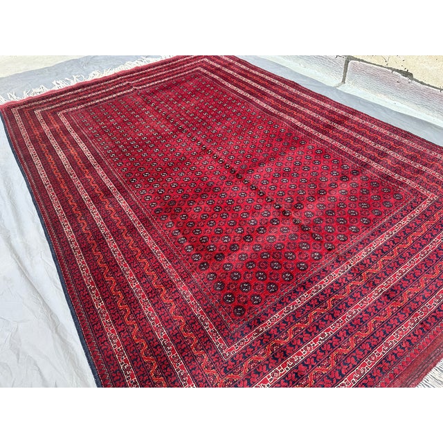 This finely woven Tekke Bokhara rug showcases tightly packed rows of small octagonal "elephant's foot" guls in deep navy...