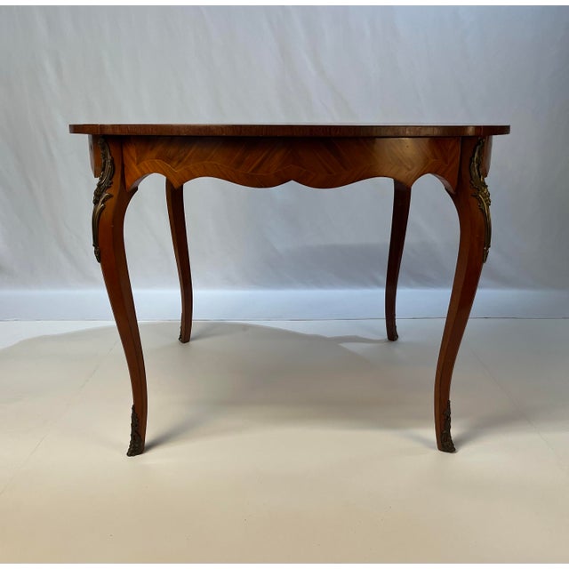 A fine mid-century occasional table, hand-crafted in France. This piece is an exceptional example of Parisian furniture-...