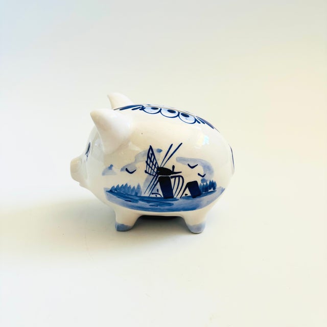 A vintage Delft ceramic piggy bank. Lovely hand painted designs and a rubber stopper in the base. Made in Holland....