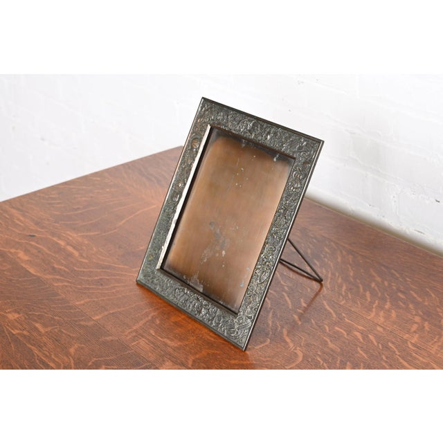A gorgeous English traditional bronze picture frame featuring a motif of knights, crests, and heraldic symbols By Louis...