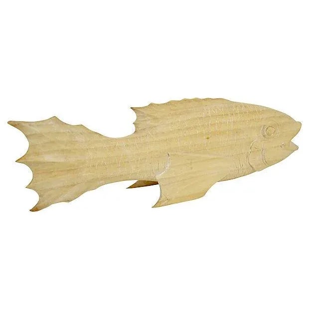 Hand-carved wood koi - like fish with highly textured fins, body, and tail in a natural light natural beige accented by a...