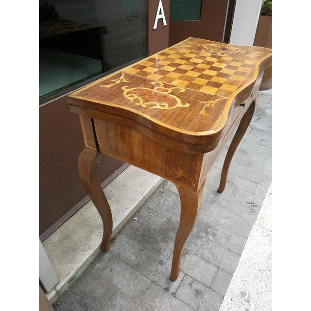 Beautiful mid-eighteenth-century game table in walnut wood and veneered in various woods, on which maple wood inlays with...