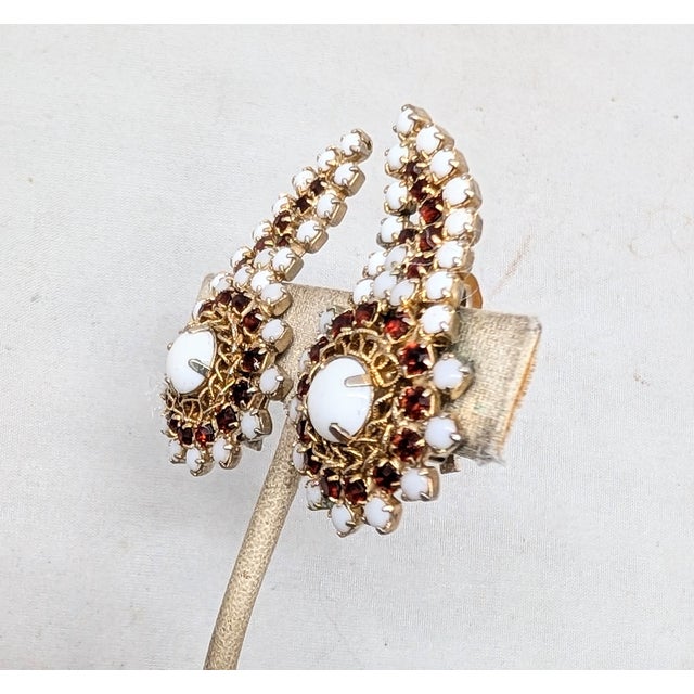 1960s goldtone prong set round bottom with prong set white cabochon rhinestones and round red rhinestones with a climber...