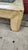 Distressed Leather coffee table has a rectangular glass top insert. The frame is covered in a cream-colored material with...