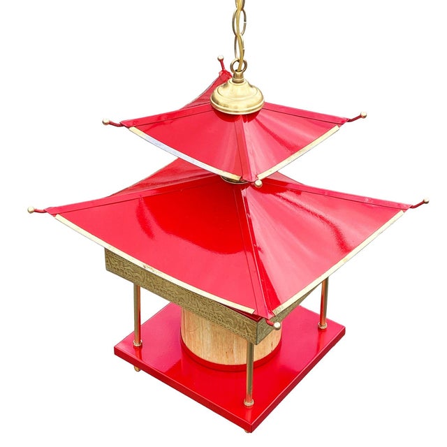 Original Mid-century era tole pagoda double-tier chandelier.. Red Enameled and brass plated accents. Embossed Asian design...