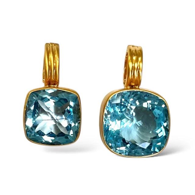 Beautifully faceted Blue Topaz enhancers both cushion cut. One is 53 carats and the other 34 carats. Pendants are...