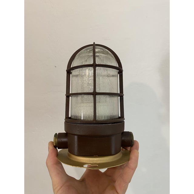 Restored vintage industrial caged bulkhead light, dating approximately from the 1970s. The lamp features a robust metal...