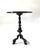 Elegant bronze side table featuring a striking round dark marble top with subtle natural veining. The table rests on a...