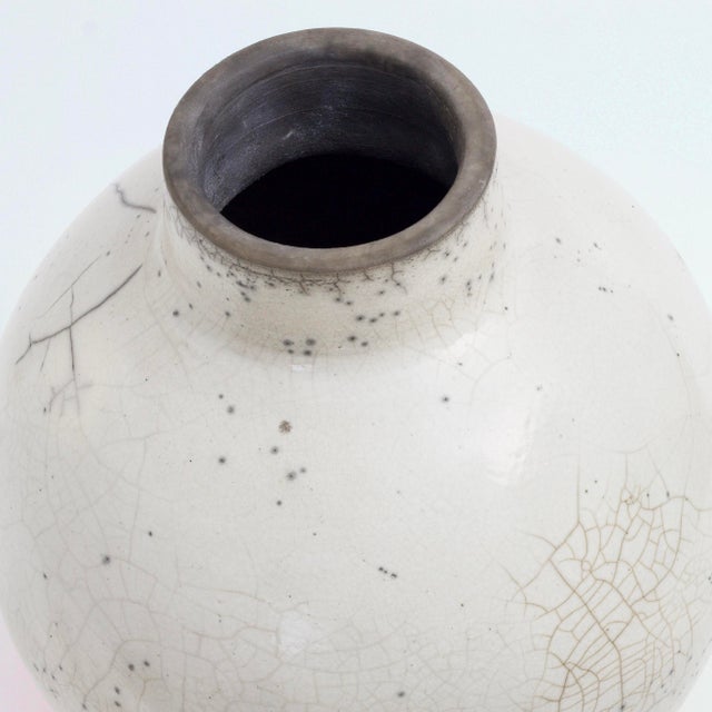 A bulging body marked by generous curves and enlivened by tiny dark speckles defines this exquisite ceramic vase, whose...