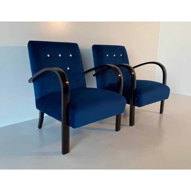These elegant armchairs were produced in the 1930s in Italy. The armrests and feet are in black lacquered solid walnut....