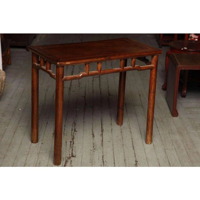 This 19th century Chinese small console or wine table was made with elmwood during the Qing Dynasty (1644-1912). The table...