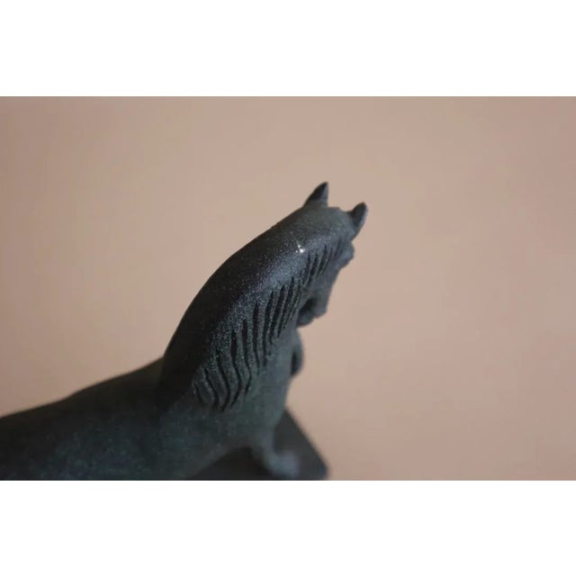 Horse statuette with dark green patina finish.