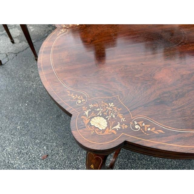 This antique English Rosewood center table features a string inlay with flowers, adding a touch of elegance to any room....