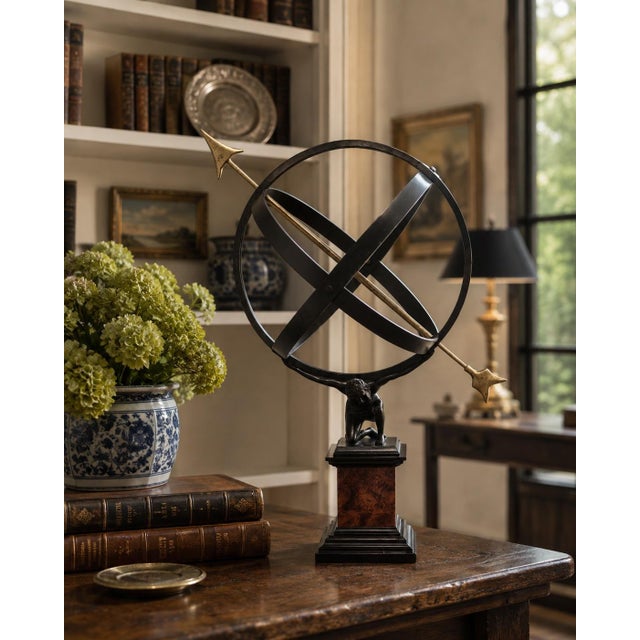 A Grand Tour–style classical armillary sphere being held up by the mythological figure Atlas, mounted on a square burl...