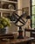 A Grand Tour–style classical armillary sphere being held up by the mythological figure Atlas, mounted on a square burl...