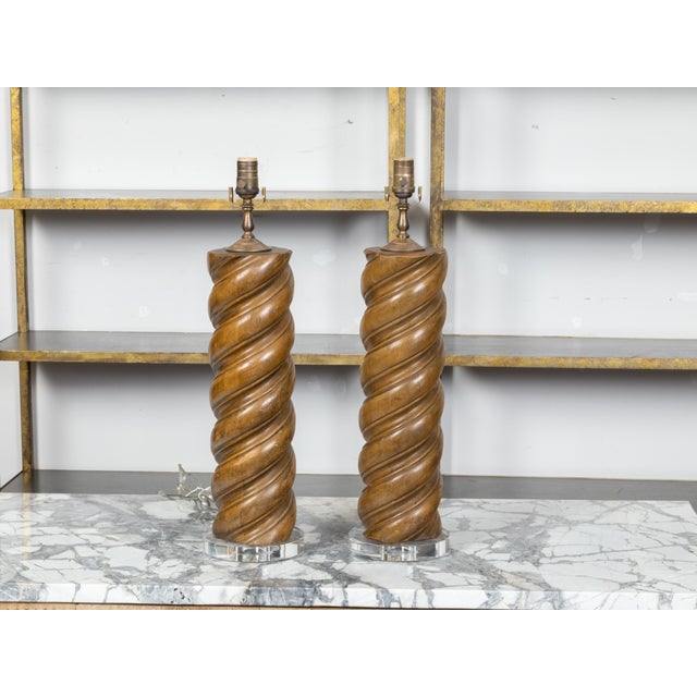 A vintage pair of French wooden table lamps from the mid 20th century, with twisted Solomonic column style motifs and...