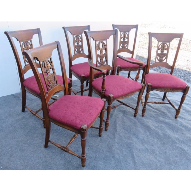 6 French Oak Carved Dining Chairs. Back carved with centerpiece of an urn with plumes. Red floral upholstered seats. Base...