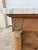 French 19th Century Empire Commode, crafted in bleached mahogany with a beautifully veined Carrara marble top. Featuring...