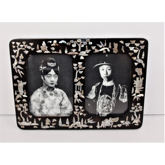A rare early 1900’s Papier Mache Chinese double window picture frame. Frame is inlaid with Mother of Pearl figures and...