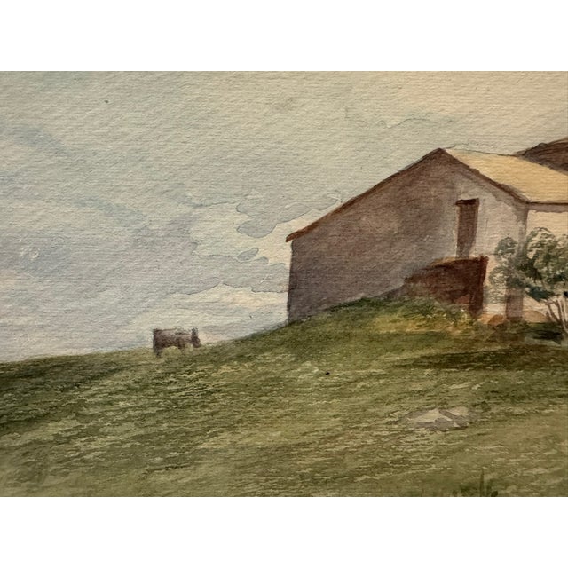 Original watercolor on paper depicting a quiet rural landscape with a farmhouse or agricultural building on a grassy...