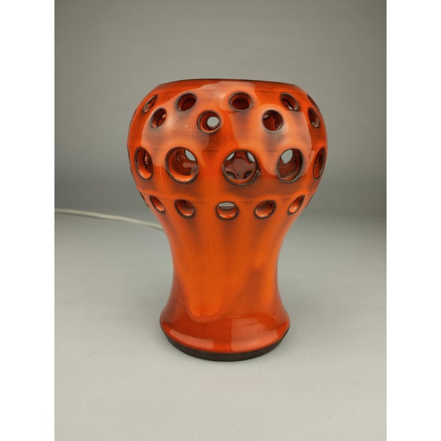 The small ceramic table lamp with orange running glaze from the 1970s is a signed work by the Swedish ceramicist Johan Ove...