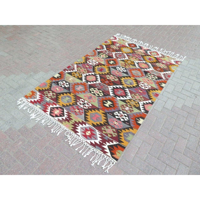 This beautiful, traditional vintage, flatweaved Turkish kilim rug is approximately 60 years old. It is handmade of very...