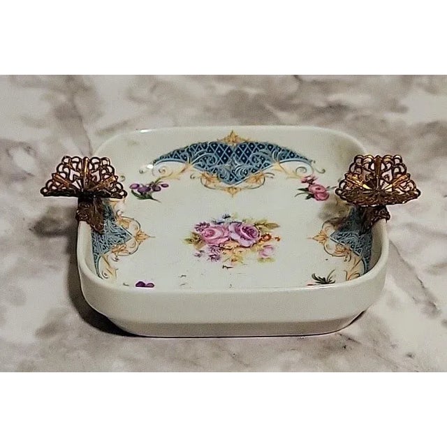 Beautiful petit porcelain vanity dish with handpainted florals and brass accents.