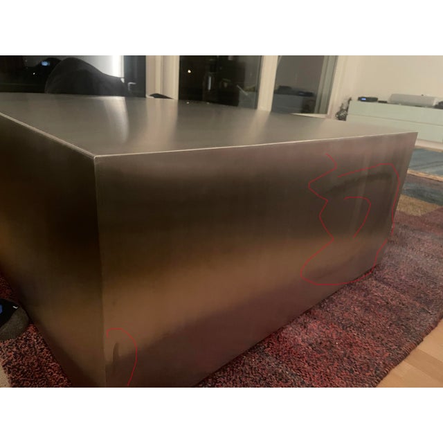 A minimalist sculptural ottoman handcrafted from brushed stainless steel. Featuring a clean monolithic silhouette and...