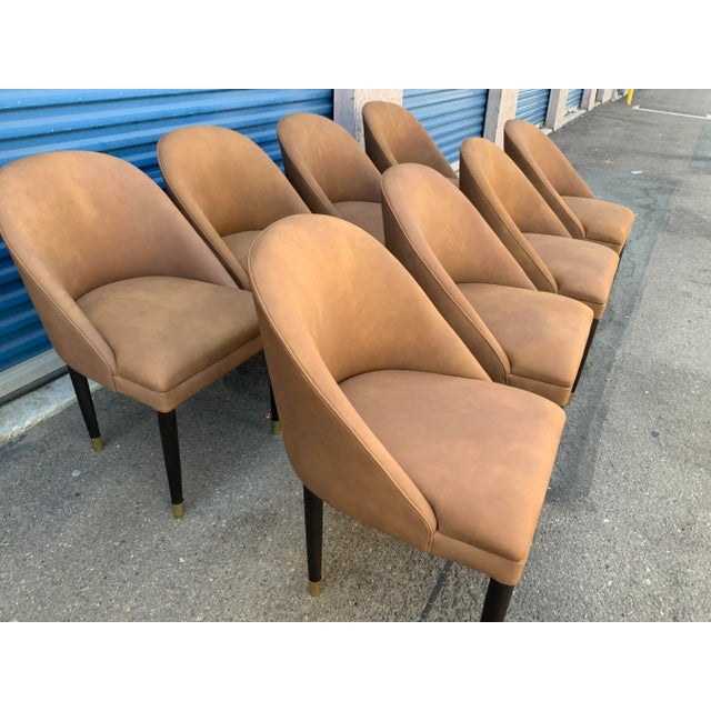 Modern set of modern dining bucket chairs. The chairs are done in a brown leather, distressed. The wood is a dark walnut ....