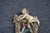 Hand-carved Italian wall mirror in the Baroque style featuring a reclining winged cherub above a rustic frame adorned with...