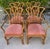 Set of four vintage rattan dining chairs featuring a sculptural fan back design with gracefully curved supports and hand-...