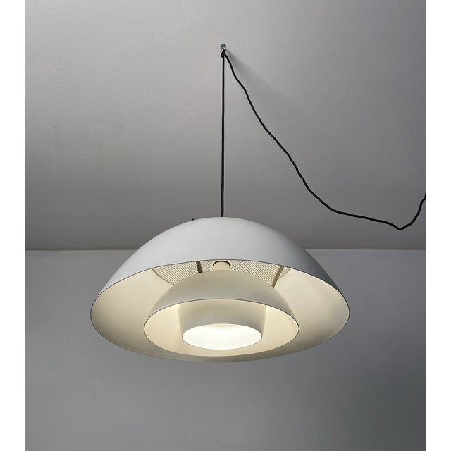 Chandelier made of white painted metal, made up of several overlapping caps that create plays of brightness. The upper...