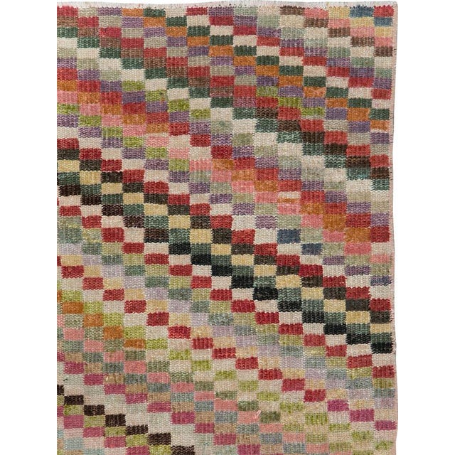 This mid-20th-century Turkish Anatolian accent rug presents an energetic checkerboard composition formed from small square...