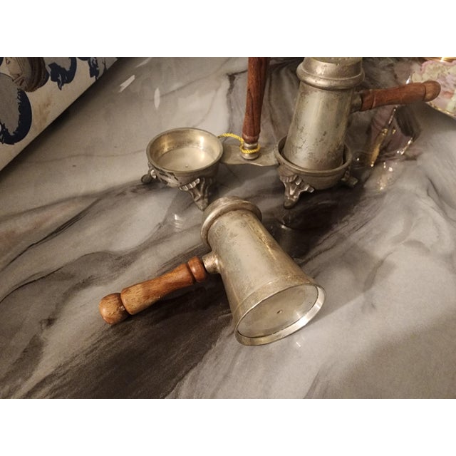 vintage metal salt and pepper shaker set with a matching handled caddy. The metal is most likely pewter or silver.