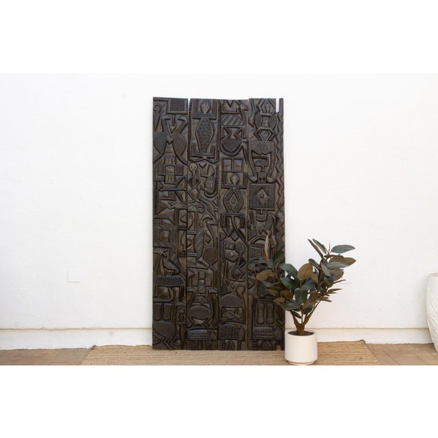 Standing nearly seven and a half feet tall, this vintage Nupe door from Nigeria is carved across four vertical planks with...