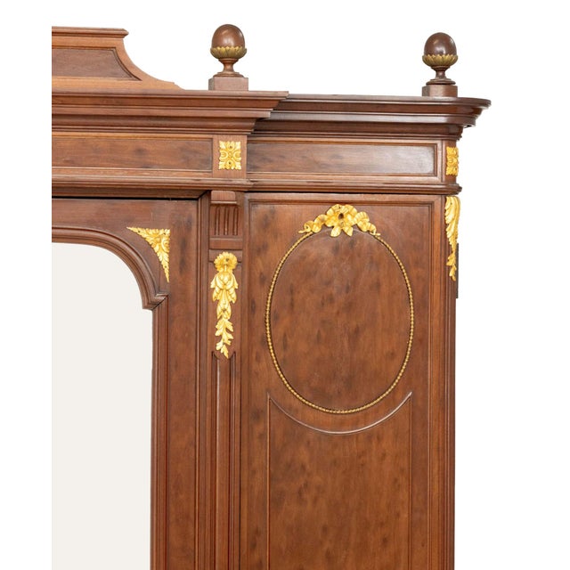 Louis XVI Style Ormolu Mounted Walnut Armoire, the central door with beveled glass mirror and flanked by two doors with...