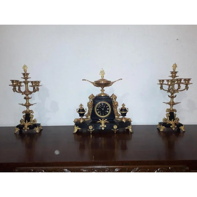 Triptych era Deco composed of a clock and deU candlesticks, of beautiful quality in black marble from Belgium and golden...